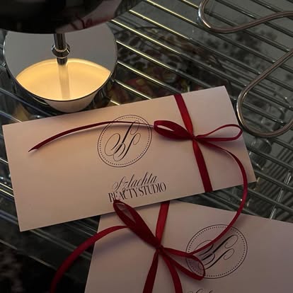 Bon podarunkowy Szlachta Beauty Studio przewiązany czerwoną wstążką